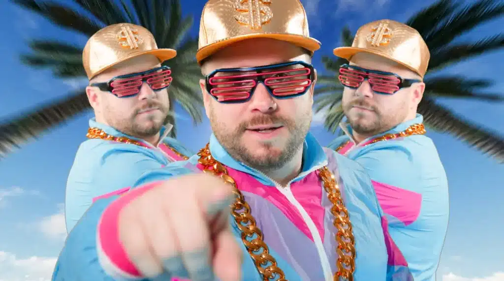 Drei Männer in bunten Jacken, goldenen Mützen und roten Rollläden posieren vor Palmen und blauem Himmel im Hintergrund.